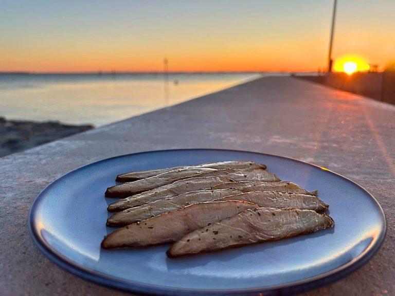 Filet d'esturgeon fumé tranché dans une assiette bleue