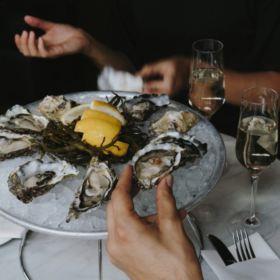 Plate d'huîtres avec tranches de citron et deux flûtes de champagne.